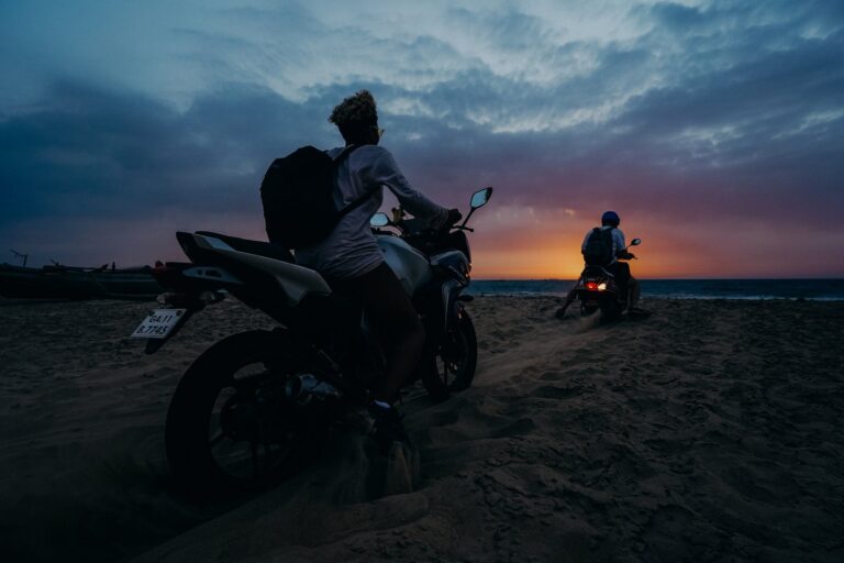 Man and Woman Riding Motorcycle on Beach during Sunset