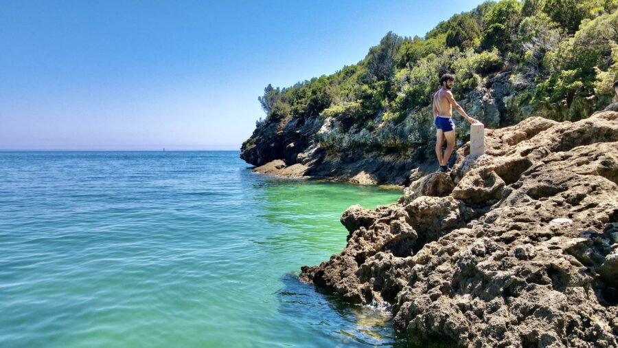Man in Blue Shorts Standing on Rocks