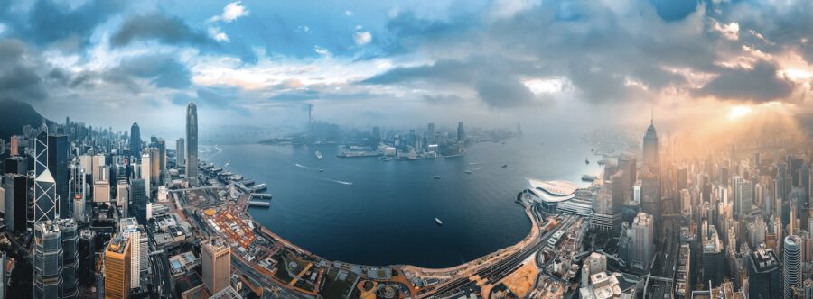 city buildings near body of water under cloudy sky