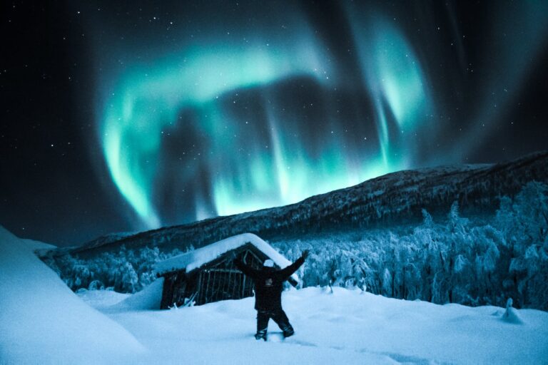 Person on White Snow Field Under Blue Starry Sky