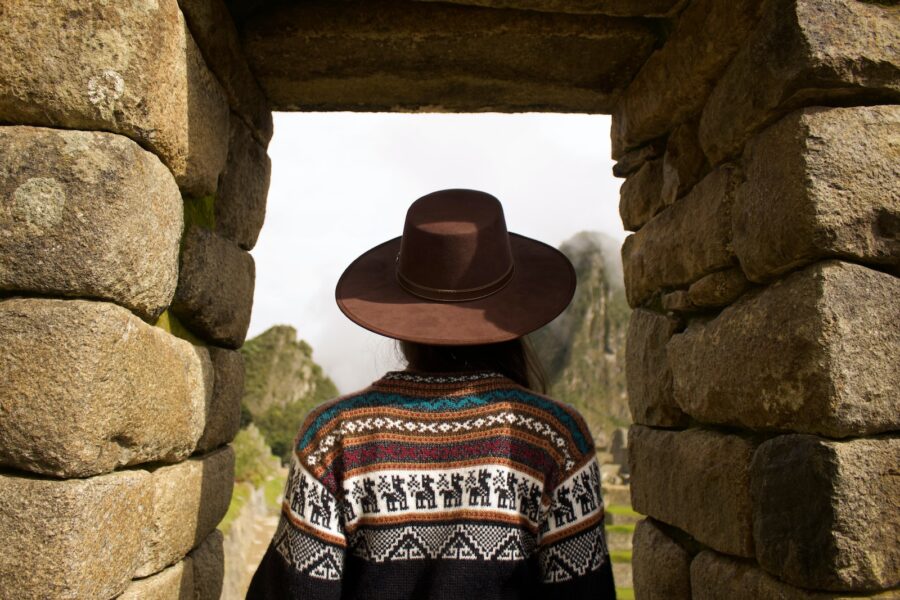 woman standing under brown rock formation
