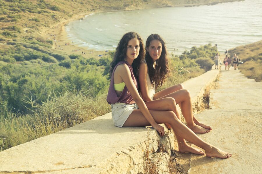Photo of Teenage Girls Sitting on the Pavement