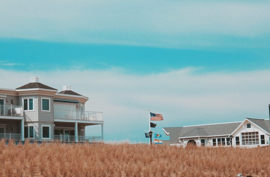 white and gray house on brown grass field under blue sky during daytime