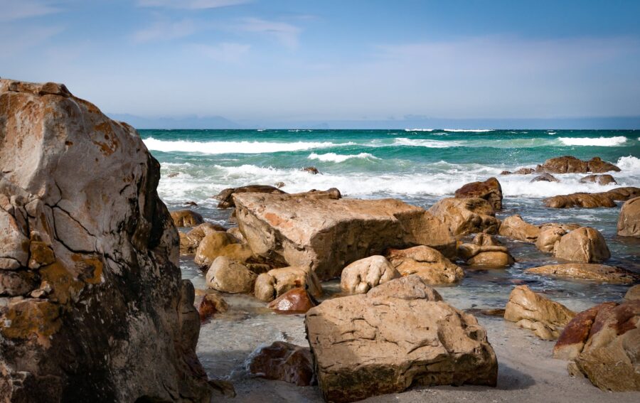 Seashore With Rocks Under Blue Sky