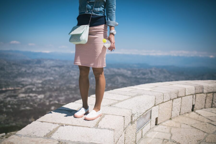Woman in Blue Denim Jacket and Pink Skirt Standing on Concrete Pavement