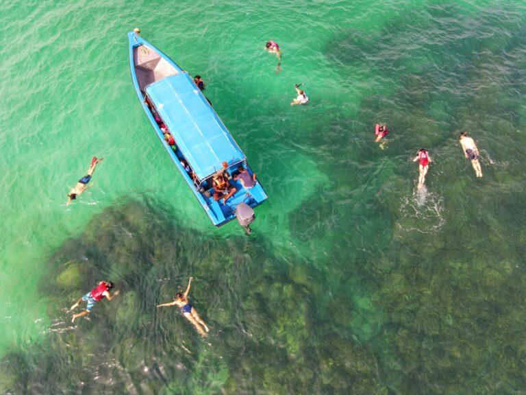 people in blue and white boat on body of water during daytime