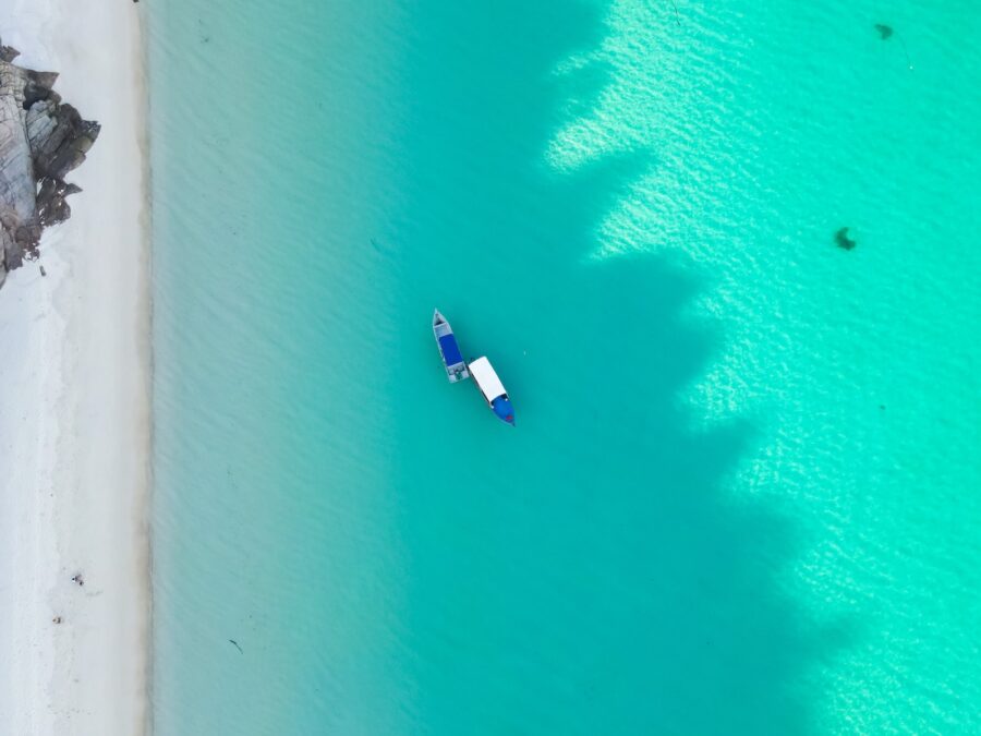 white and blue boat on blue water