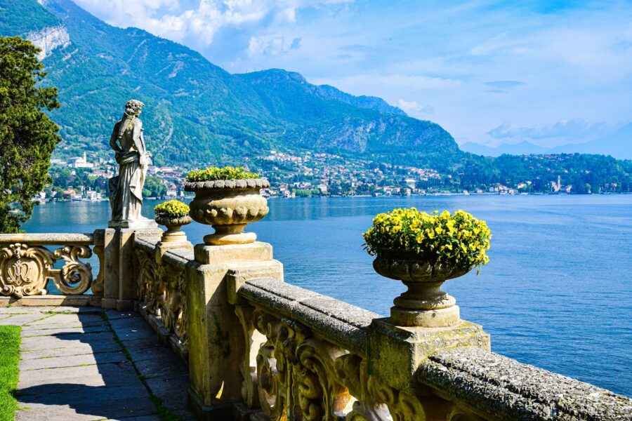 a statue on a stone wall overlooking a body of water