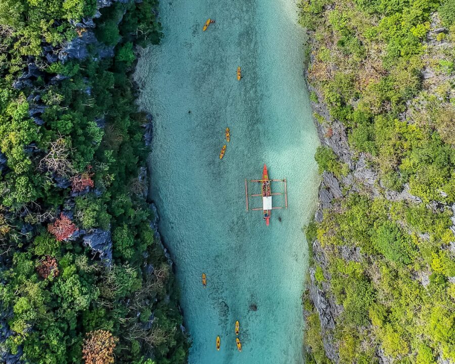 aerial view of boat on body of water between trees during daytime
