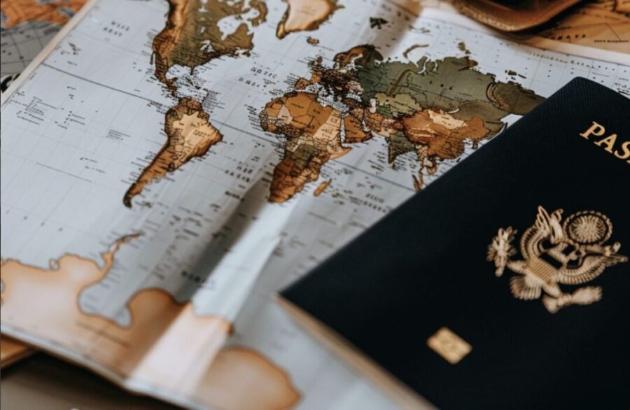 a passport and financial documents placed on a world map