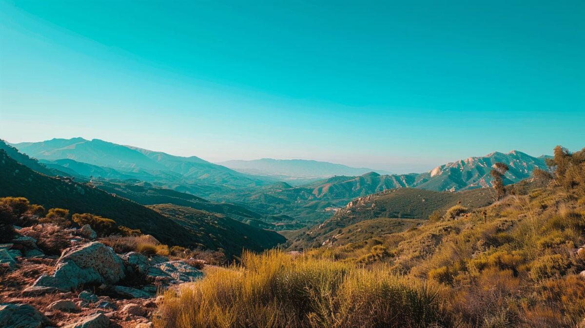 A serene mountain landscape under a clear blue sky.